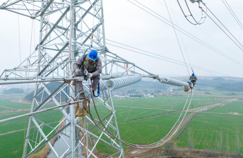 电网建设人员为新建220千伏线路安装引流线。陶洋摄