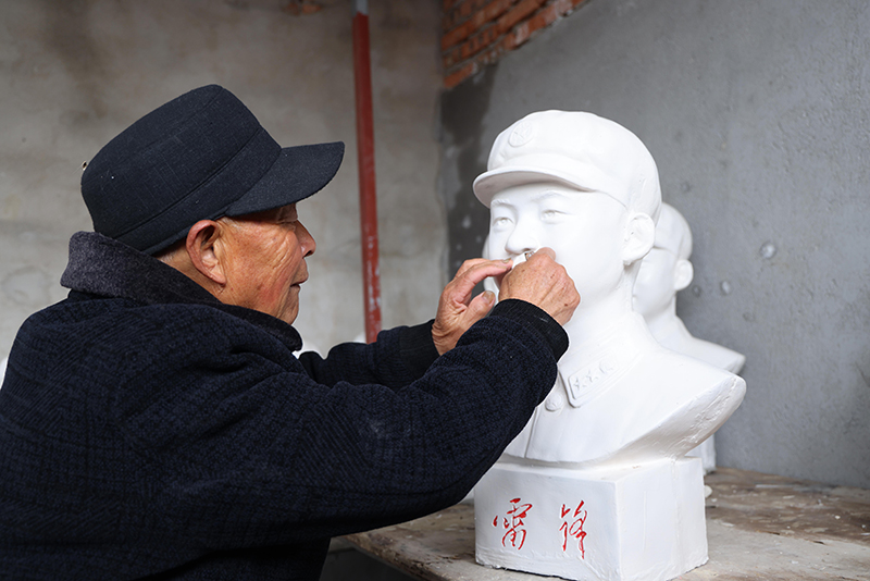 来振先正在打磨新制作的雷锋塑像。李雪蕊摄