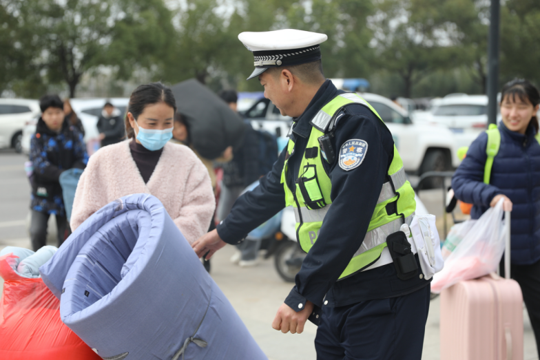 交警主动帮助学生和家长搬运大件行李。