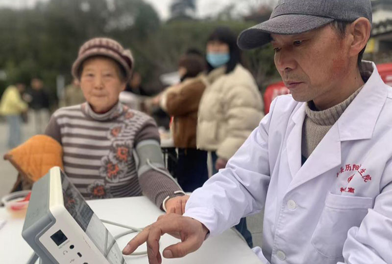 朝阳社区卫生室主任刘明使用“健康一体机”为居民测量血压。
