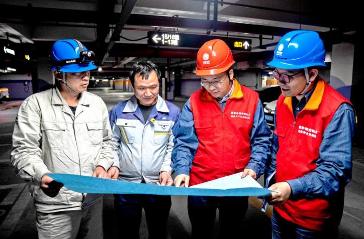 芜湖供电公司工作人员联合小区物业人员研究充电桩建设方案。高磊摄