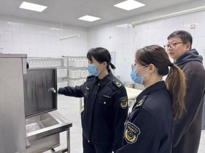 区市场监管局执法人员检查校园食品安全。
