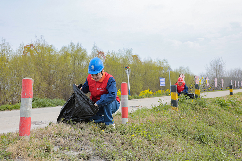 和縣供電公司組織青年職工在學雷鋒紀念日當天沿著長江岸線義務撿拾垃圾。王平攝 (2)