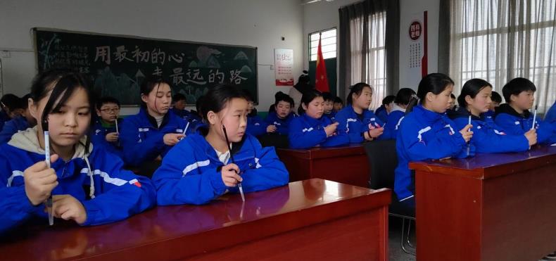 同學們在模仿握筆姿勢。