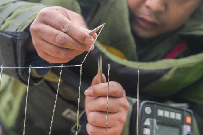 细线在排爆队员手中穿过针孔
