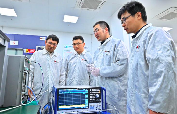 唐世彪(左3)带领团队成员在调试超导量子计算机的测控系统。程兆摄