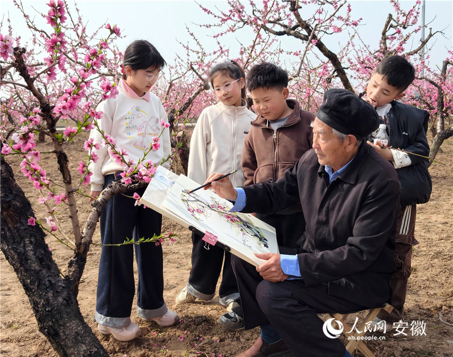 八十三岁农民书画家刘世德桃园写生,引来小学生驻足观赏。人民网 陶伟摄