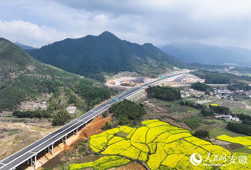 远处的服务区正在抢抓春季施工黄金期进行收尾工程。人民网记者 王锐摄