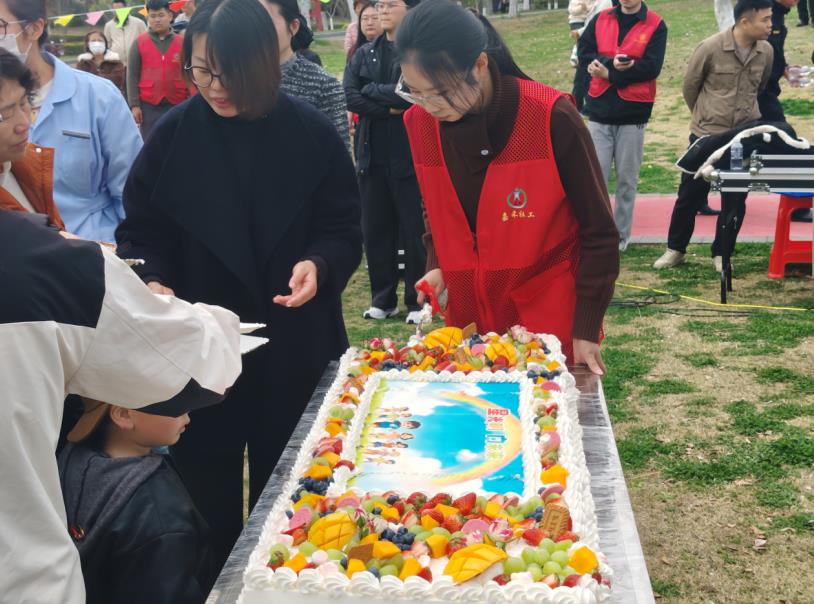 野餐休息區，工作人員正為參與家庭分發蛋糕。申超凡攝