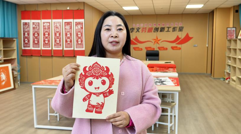 李文展示省运会剪纸作品。灵璧县委宣传部供图