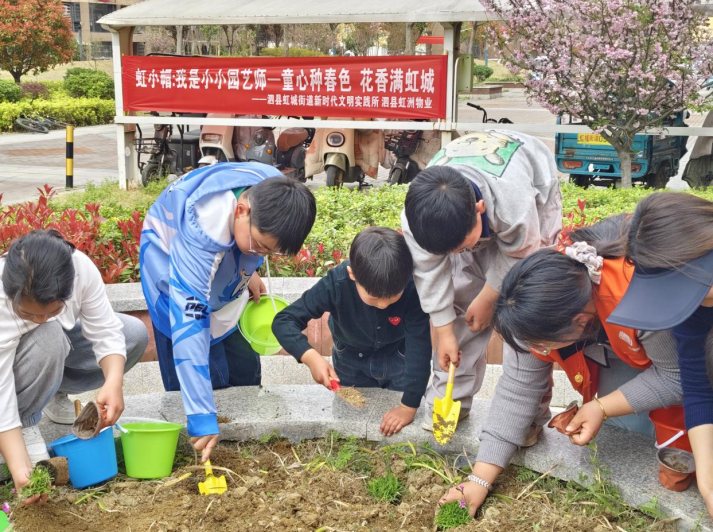 小朋友们用小铲子松土、挖坑、栽苗。顾梦琦摄