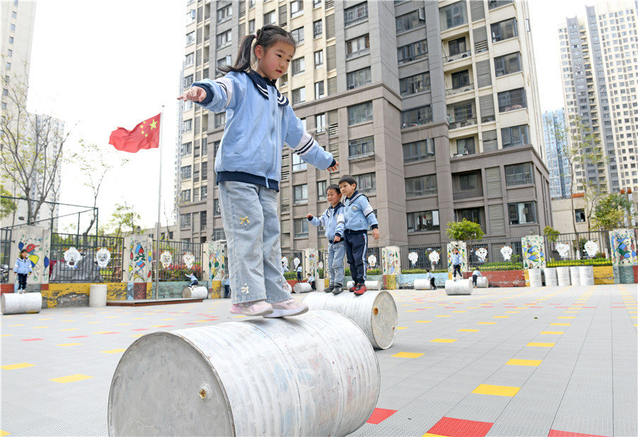 小朋友开展滚铁桶趣味游戏，练习身体平衡力和协调性。
