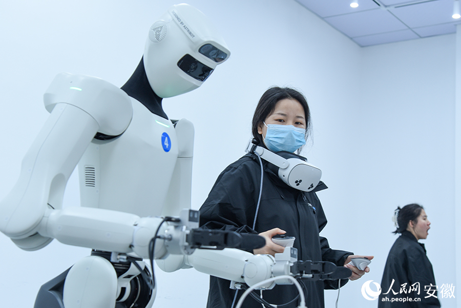 具身机器人正在训练师的操控下，反复训练动作。人民网记者 李希蒙摄