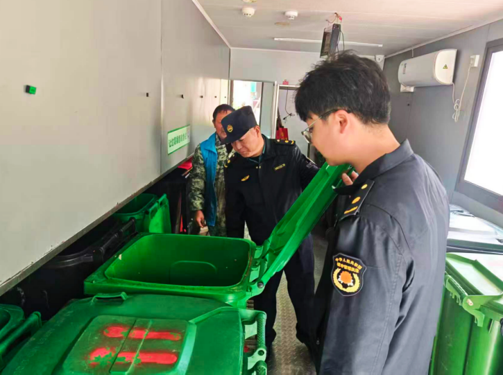 城管人员检查小区垃圾投放点