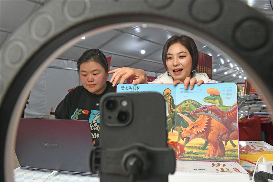 安徽淮南新華書店工作人員在淮南市2026年“全民閱讀活動周”暨春季惠民書展現場通過網絡直播銷售圖書。