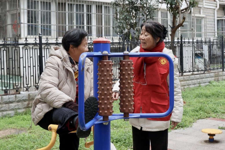 老人在小区内新安装的健身器材锻炼身体