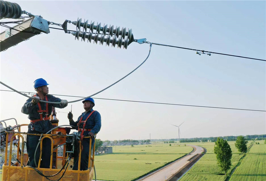 在安徽省亳州市渦陽縣天靜宮街道辦事處凡西村，電力工作人員正在渦陽縣110千伏焦北771線01號塔上進行高空架線作業。