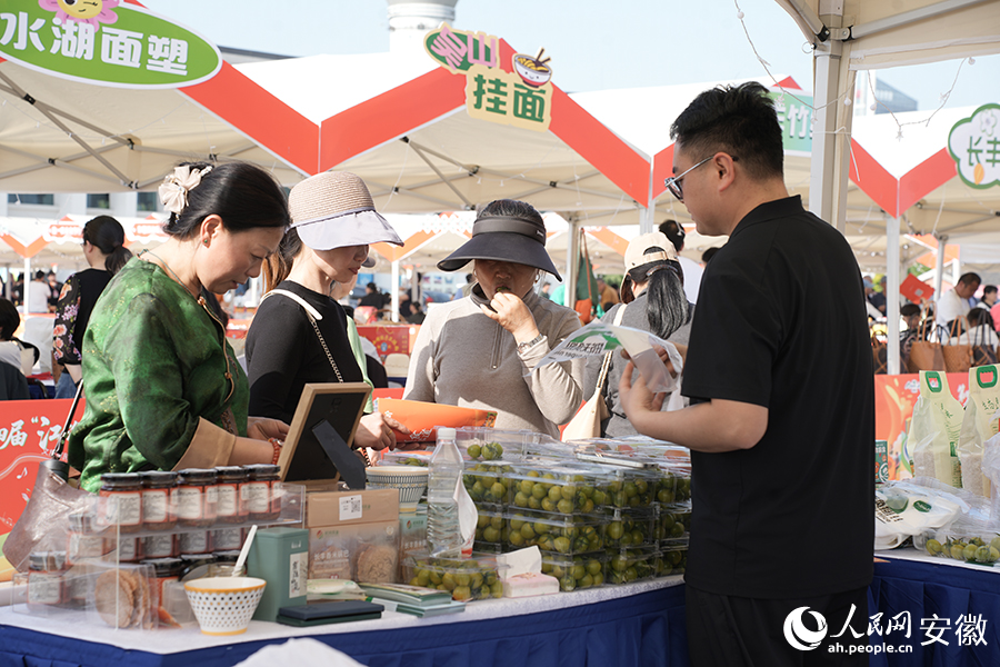 市民在展台上購買農特產品。人民網記者 王銳攝