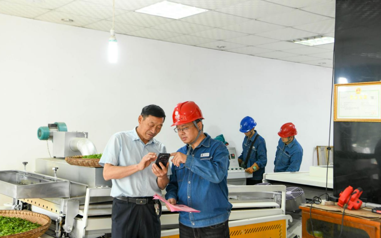 舒城供电公司员工为茶农演示车网互动操作方法。李锐摄