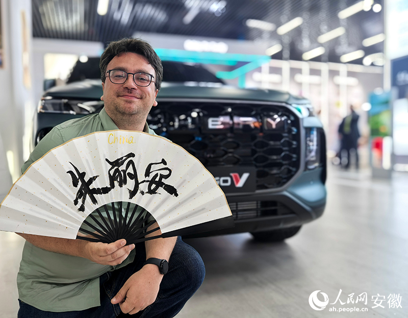 朱丽安拿着写有自己名字的扇面拍照留念。人民网记者 汪瑞华摄