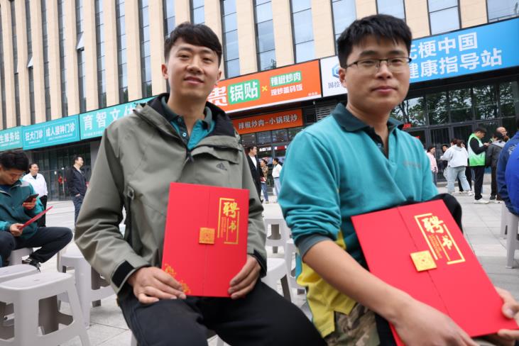 受聘快遞員接收聘書。