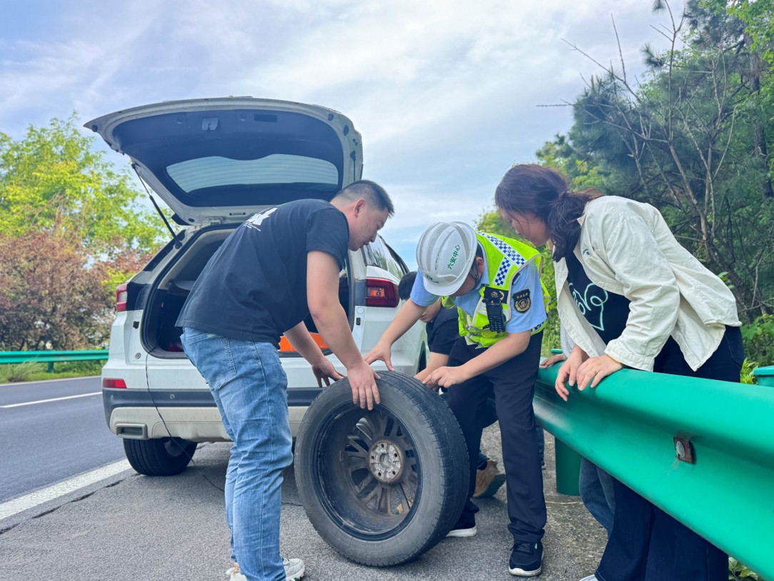 六安中心六岳分中心大别山东中队在巡查途中帮助车辆更换备胎。皖通公司供图