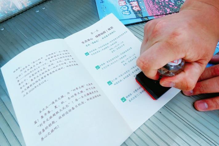 游客在打卡點為自己的“通關文牒”蓋章。