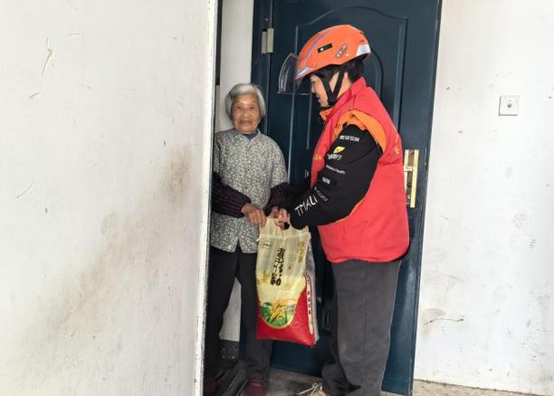 志願者為“窗帘之約”服務對象代買米。長豐縣水湖鎮供圖