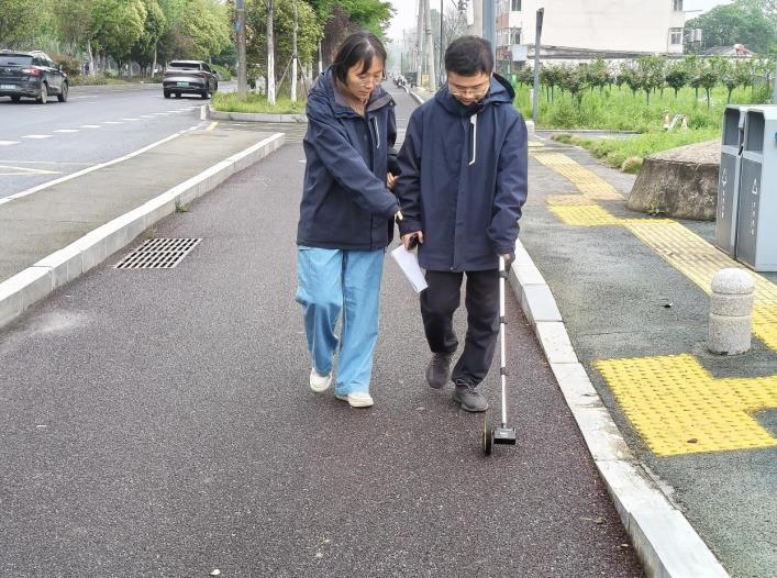 燃氣工作人員用滾輪測距儀測量燃氣管線距離。