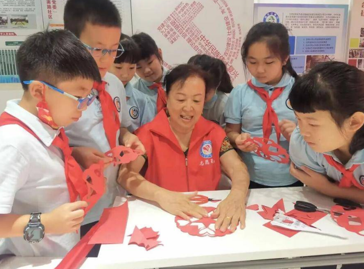 “五老”志愿者组织青少年开展剪纸活动。