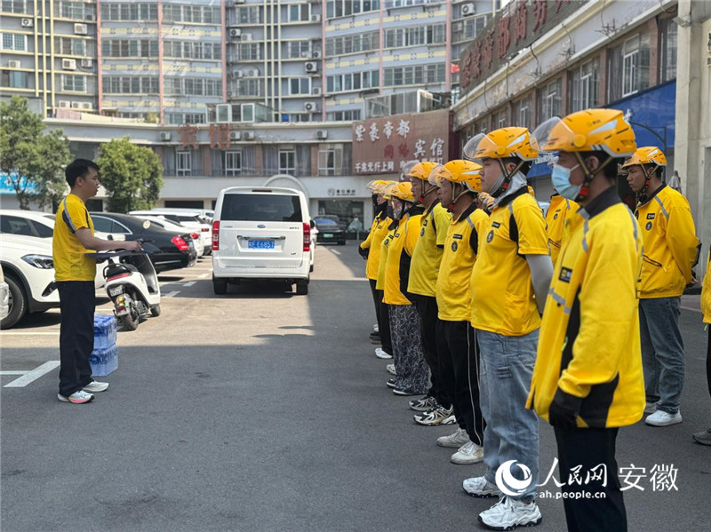 代冬祺（左）给大家开早会。 人民网记者 吕欢欢摄