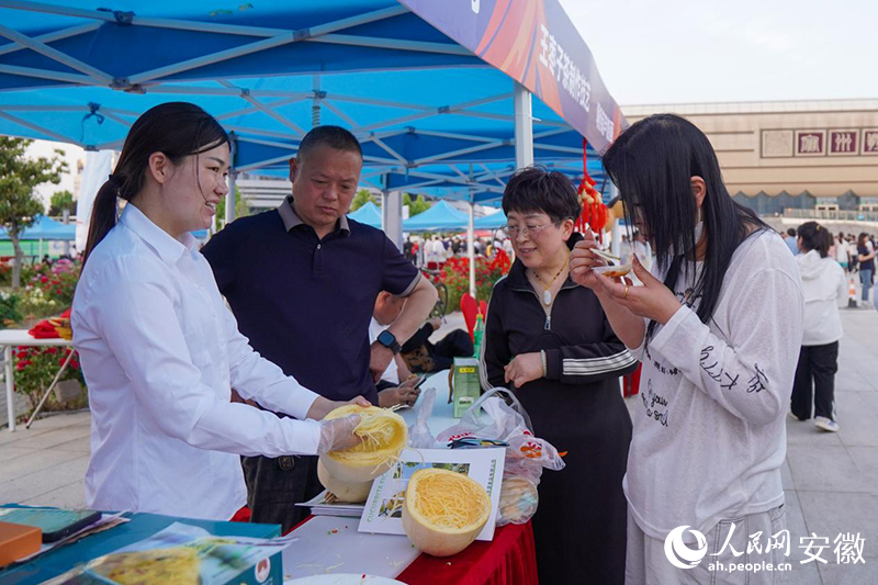 “徽BA”宿州主场旁的市集上，球迷在品尝当地美食。人民网记者 陈若天摄