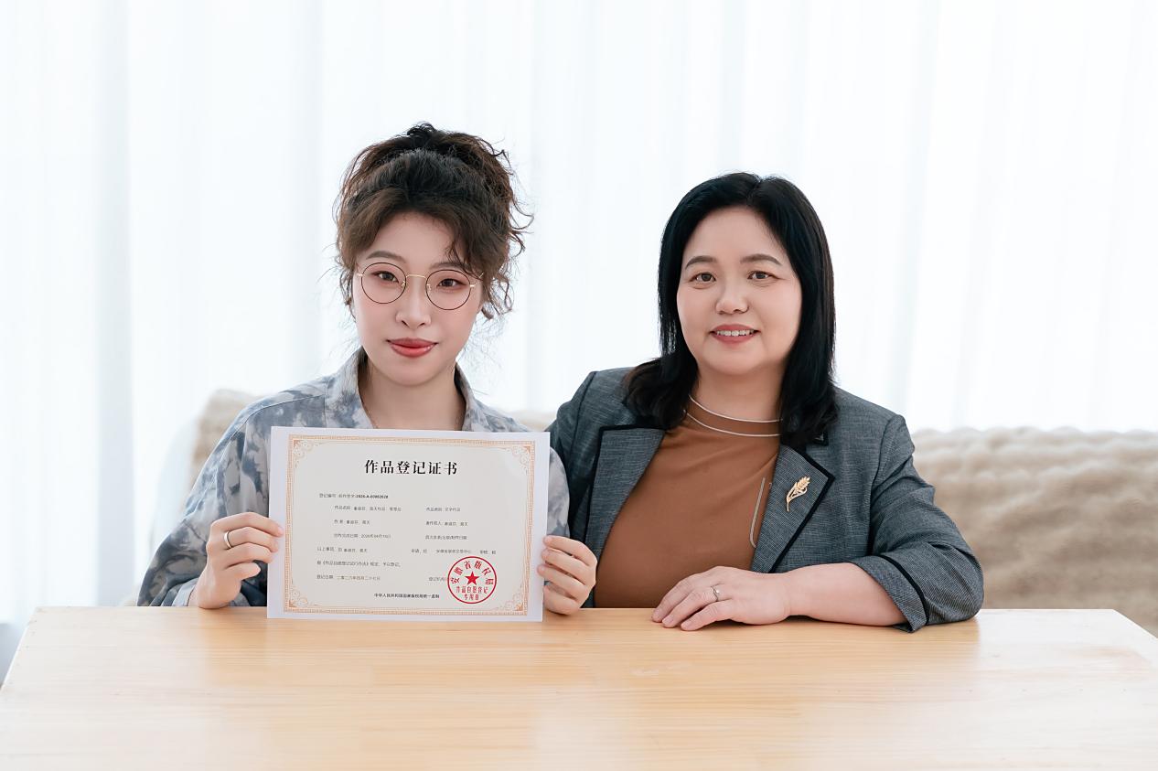 秦淑芬（右）與女兒展示安徽省版權局《作品登記証書》。受訪者供圖