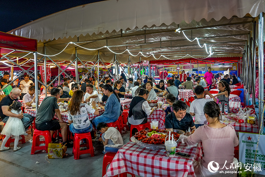 夜幕下的淮河文化廣場，眾多市民品嘗螞蝦美食。人民網記者 苗子健攝