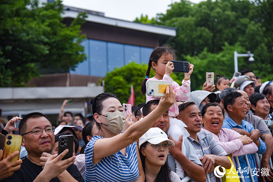 岸边的群众正在为自己支持的队伍加油。人民网记者 李希蒙摄