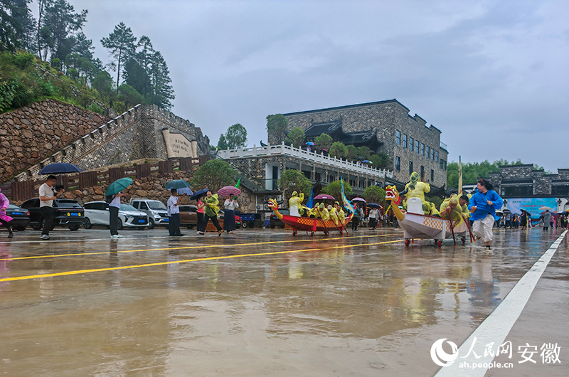 大雨掩盖不了旱地龙舟比赛场地的热闹。人民网记者 王锐摄