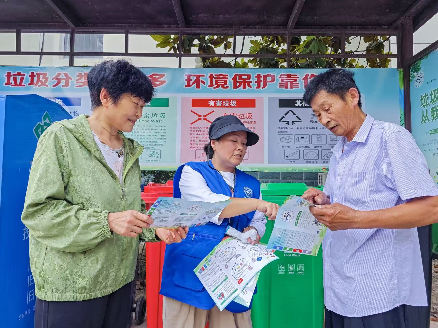 谯城区薛阁街道新都国际小区垃圾分类引导员白静正在引导居民正确投放垃圾。亳州市谯城区供图
