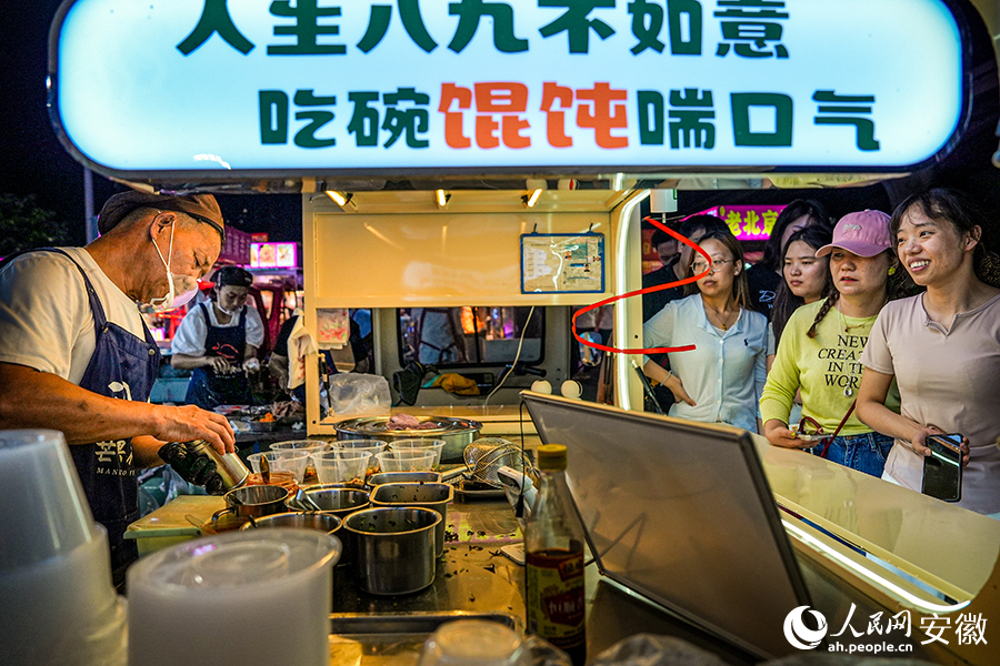在芒果夜市，人气摊位总是排不完的队。人民网记者 苗子健摄