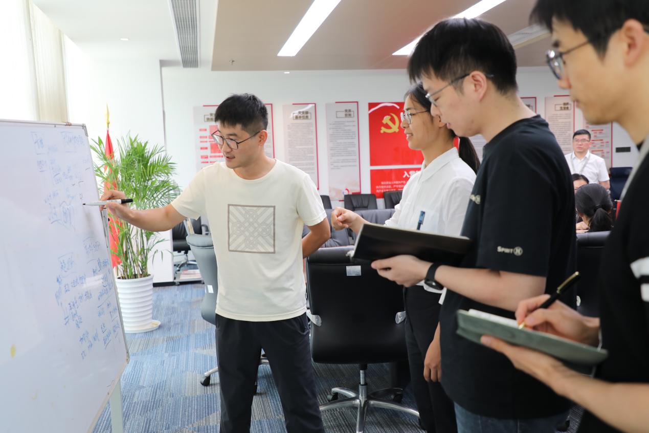 设计总院数智化事业部党总支数创中心的年轻人聚在一起讨论智能体模型搭建。设计总院供图