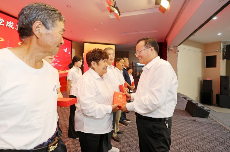 区领导为老党员颁发“光荣在党50年”纪念章。黄鹤鸣摄