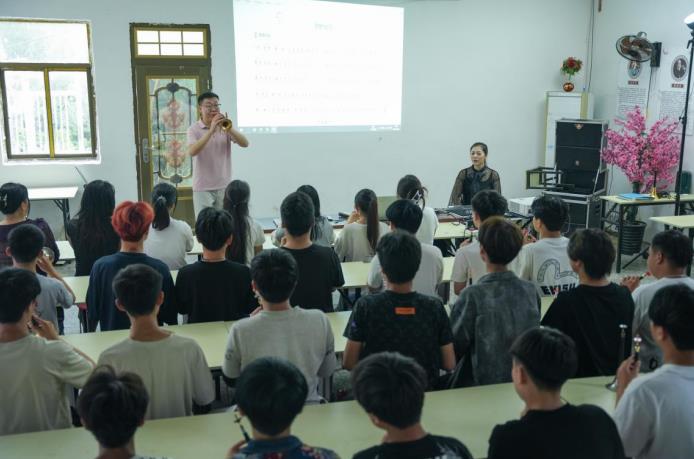 黄磊在向学员教授识谱吹奏方法。赵怀勇摄