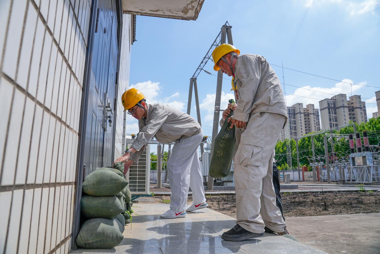 供电员工在35千伏开关室出入口码放沙袋。