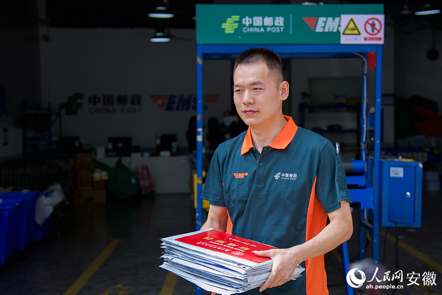 揽投员何冠华整装待发,准备递送录取通知书。人民网记者 李希蒙摄
