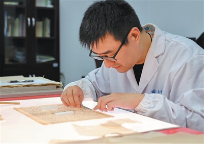 图为茆可人正在进行古籍修复。张敏摄