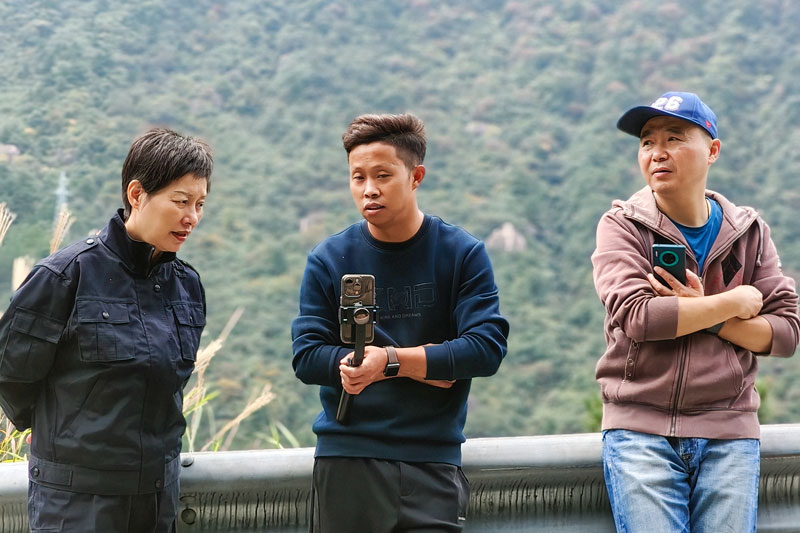 周厚旺正在向游客展示他拍的短视频。受访者供图