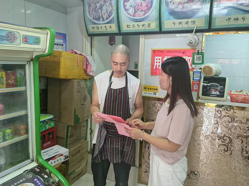 社区工作人员宣传燃气安全使用注意事项。