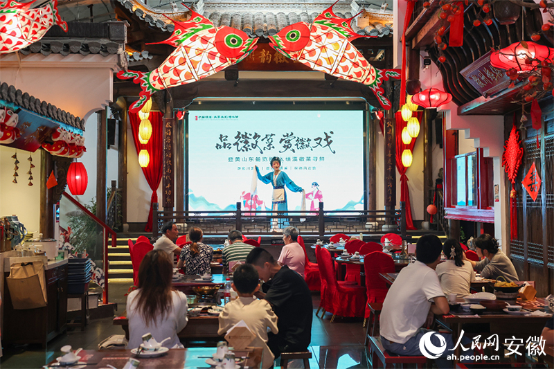 宣城绩溪县，游客一边品尝徽菜一边欣赏徽剧。人民网记者 张俊摄