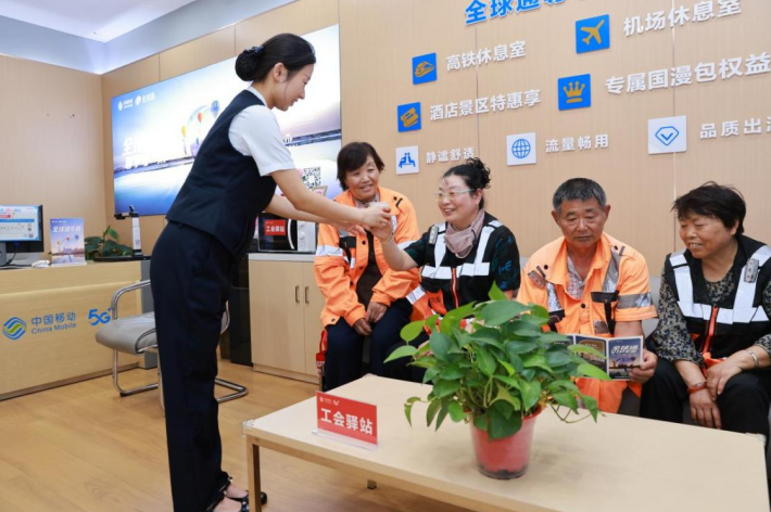 营业厅工作人员为环卫人员递上温水
