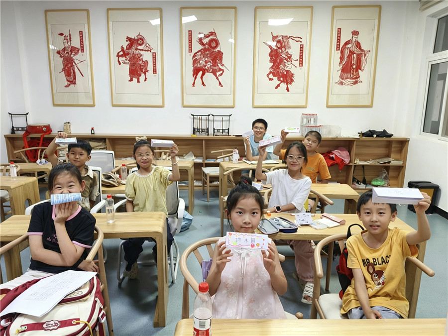 新时代文明实践中心行知学堂暑托班手工课制作姓名条。