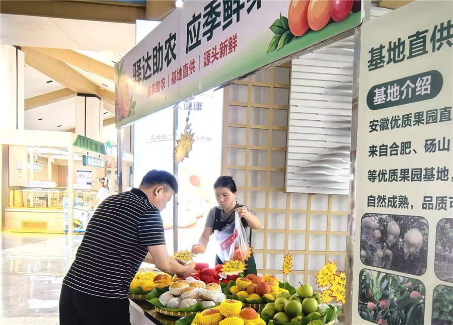 在太白岛服务区应季鲜果展销专区，工作人员协助旅客挑选水果